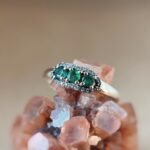 Vintage 9 karaat massief gouden ring met drie smaragden omringd met een rij van diamanten