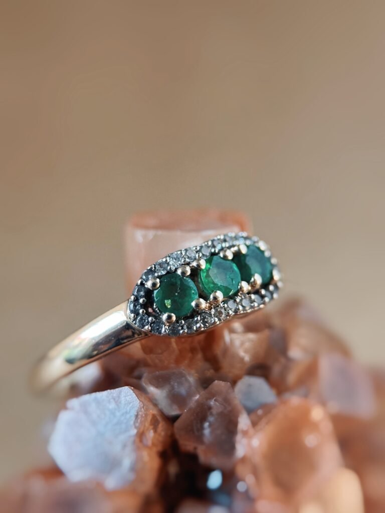 Vintage 9 karaat massief gouden ring met drie smaragden omringd met een rij van diamanten