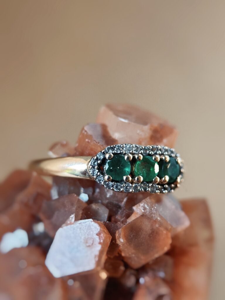 Vintage 9 karaat massief gouden ring met drie smaragden omringd met een rij van diamanten