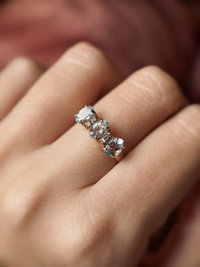Vintage 9 karaat massief gouden ring met drie aquamarijnen en diamant om hand