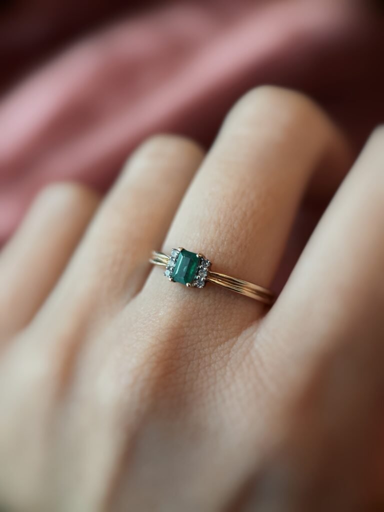 Vintage 9 karaat massief gouden ring met emerald cut smaragd en zes diamantjes Om hand