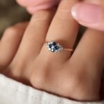 Vintage 18K gold sapphire and diamond cluster ring worn on a finger