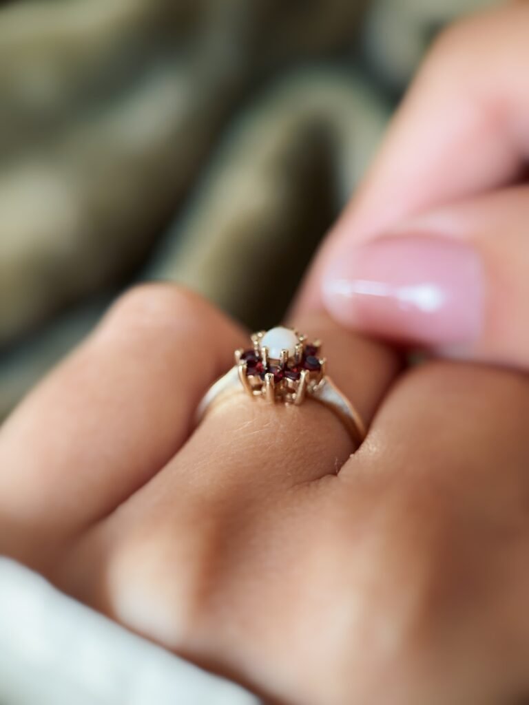 Vintage 9K gold opal and garnet cluster ring worn on a finger