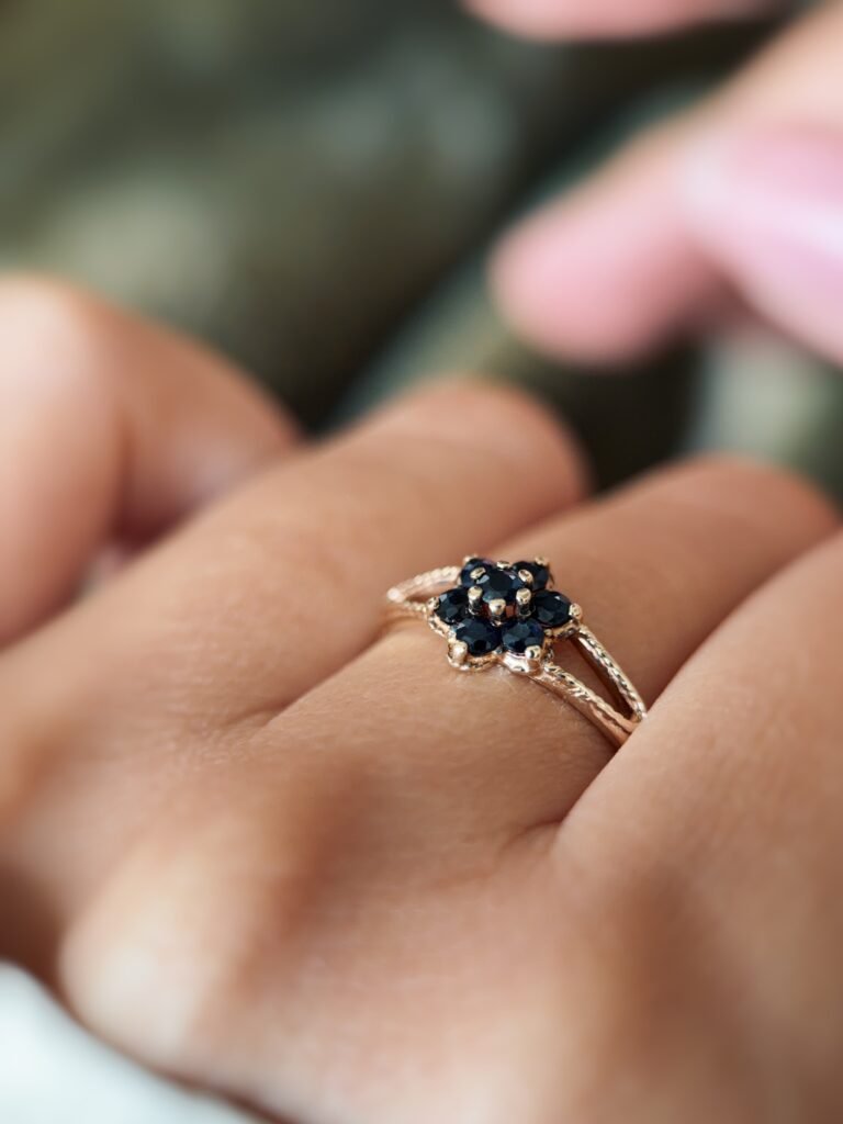 Vintage 9K gold sapphire flower cluster ring worn on a finger