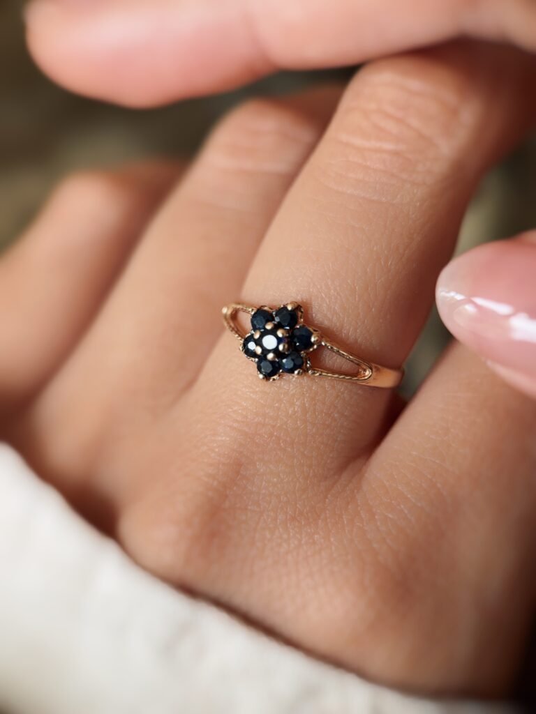 Vintage 9K gold sapphire flower cluster ring worn on a finger