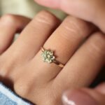 Vintage 9 carat gold daisy flower ring with peridot worn on a hand