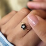 Vintage 9 carat gold sapphire and opal daisy flower ring worn on a hand