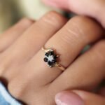 Vintage 9 carat gold sapphire and opal daisy flower ring worn on a hand
