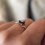 Vintage 9 carat gold sapphire and opal daisy flower ring worn on a hand