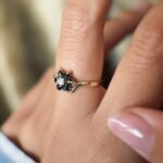 Vintage 9 carat gold sapphire and opal daisy flower ring worn on a hand