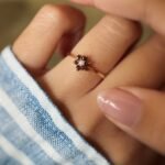 Vintage 9 carat gold pearl and garnet daisy ring worn on a hand