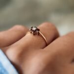 Vintage 9 carat gold pearl and garnet daisy ring worn on a hand