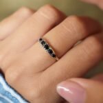 Vintage 9 carat gold five stone sapphire ring worn on a hand
