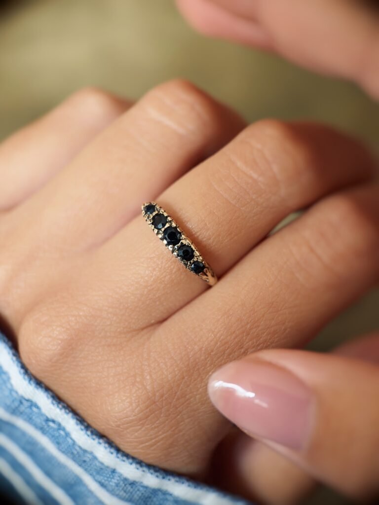 Vintage 9 carat gold five stone sapphire ring worn on a hand