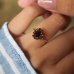 Vintage 9 carat gold garnet cluster ring worn on a hand