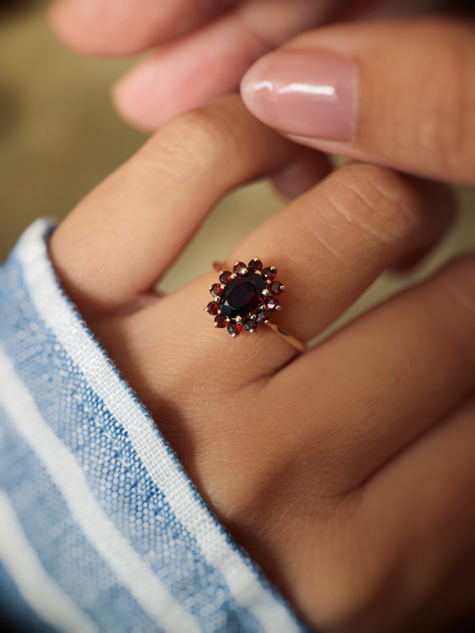 Vintage 9 carat gold garnet cluster ring worn on a hand