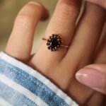 Vintage 9 carat gold garnet cluster ring worn on a hand