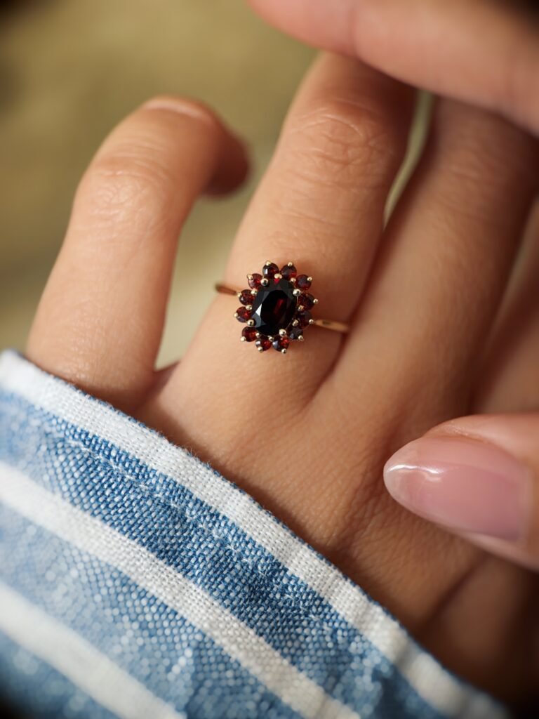 Vintage 9 carat gold garnet cluster ring worn on a hand