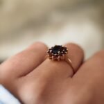Vintage 9 carat gold garnet cluster ring worn on a hand