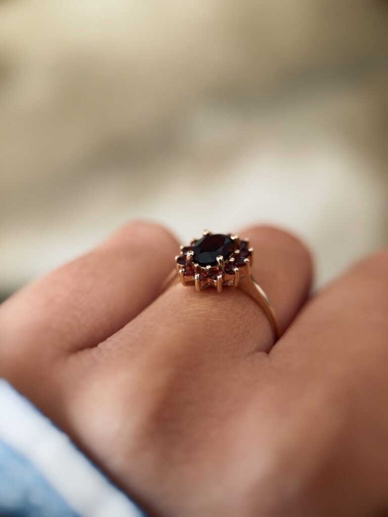 Vintage 9 carat gold garnet cluster ring worn on a hand