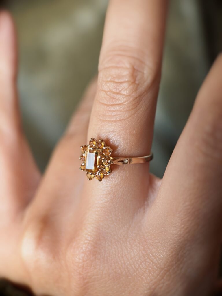 Vintage 9 carat gold yellow citrine cluster ring worn on a hand