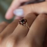 Vintage 9 carat gold dark red garnet cluster ring worn on a hand