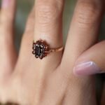 Vintage 9 carat gold dark red garnet cluster ring worn on a hand