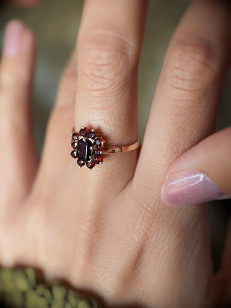 Vintage 9 carat gold dark red garnet cluster ring worn on a hand