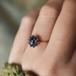 Vintage 9 carat gold dark blue sapphire cluster ring worn on a hand