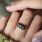 Vintage 9 carat gold sapphire and diamond triple daisy ring worn on a hand