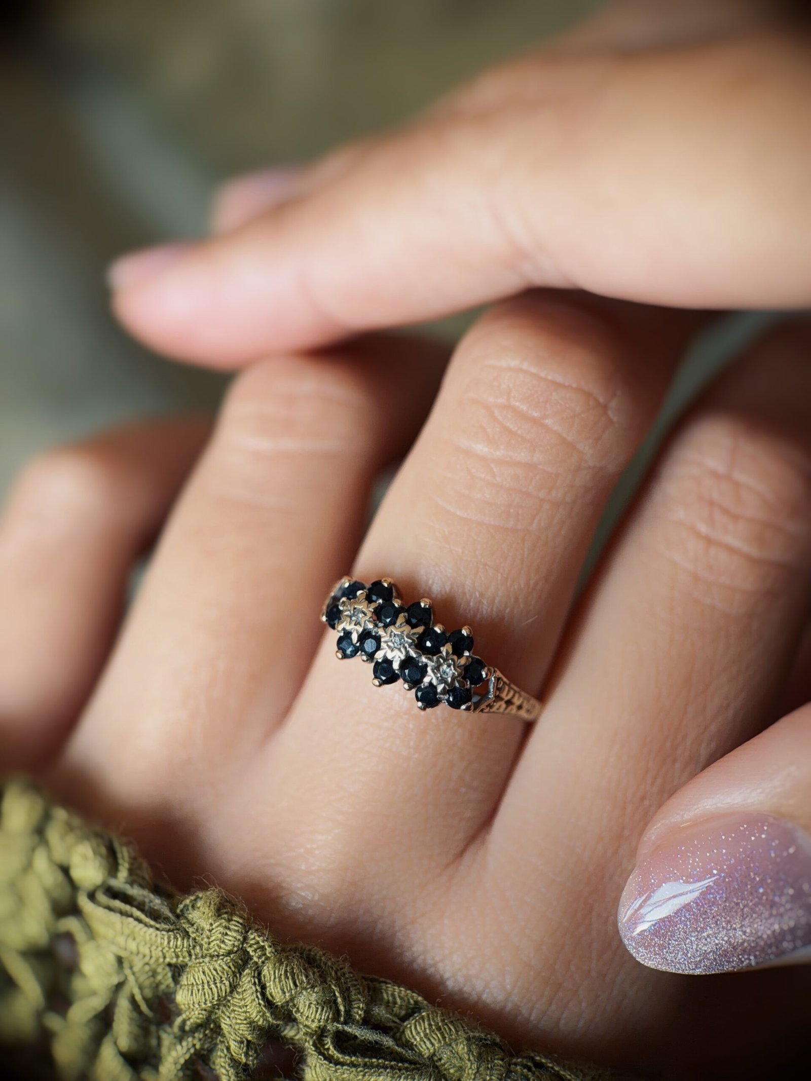 Vintage 9 carat gold sapphire and diamond triple daisy ring worn on a hand