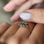 Vintage 9 carat gold sapphire and diamond triple daisy ring worn on a hand