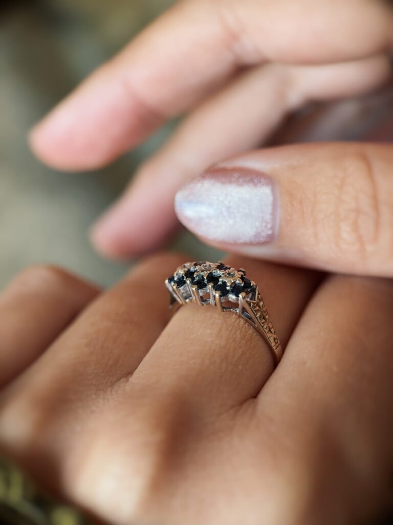 Vintage 9 carat gold sapphire and diamond triple daisy ring worn on a hand