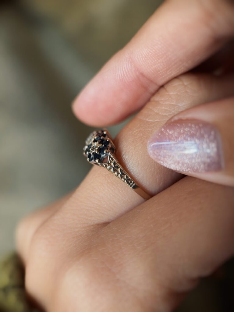 Vintage 9 carat gold sapphire and diamond triple daisy ring worn on a hand