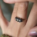 Vintage 9 carat gold sapphire and diamond triple daisy ring worn on a hand