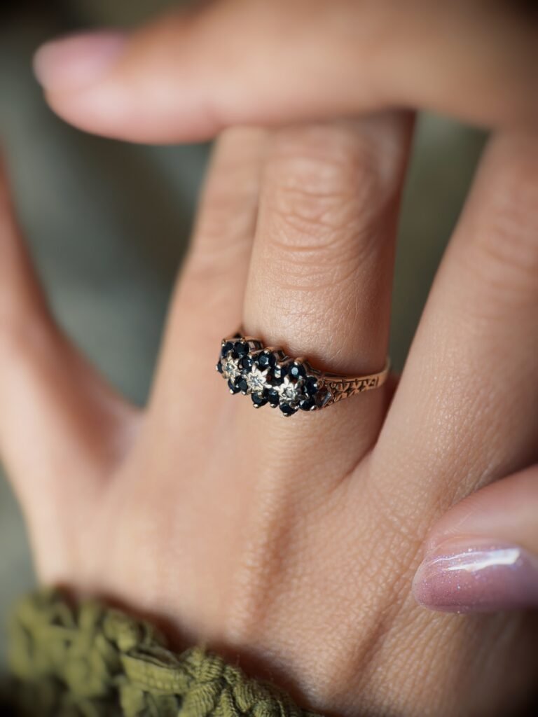 Vintage 9 carat gold sapphire and diamond triple daisy ring worn on a hand