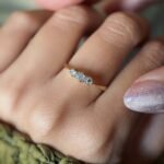 Antique 18 carat gold old european cut diamond threestone ring worn on a hand