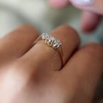 Antique 18 carat gold old european cut diamond threestone ring worn on a hand