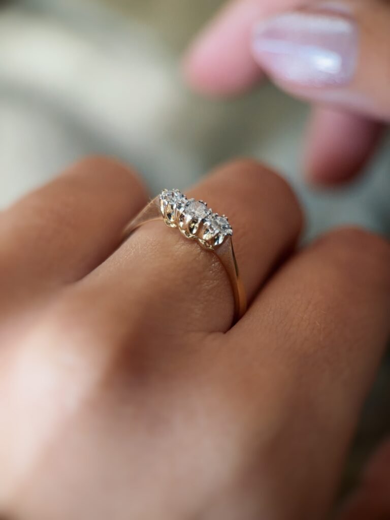 Antique 18 carat gold old european cut diamond threestone ring worn on a hand