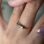 Antique 18 carat gold old european cut diamond threestone ring worn on a hand