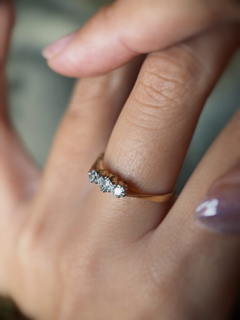 Antique 18 carat gold old european cut diamond threestone ring worn on a hand