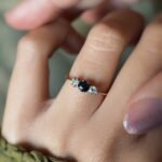 Antique 18 carat gold sapphire and old european cut diamond threestone ring worn on a hand