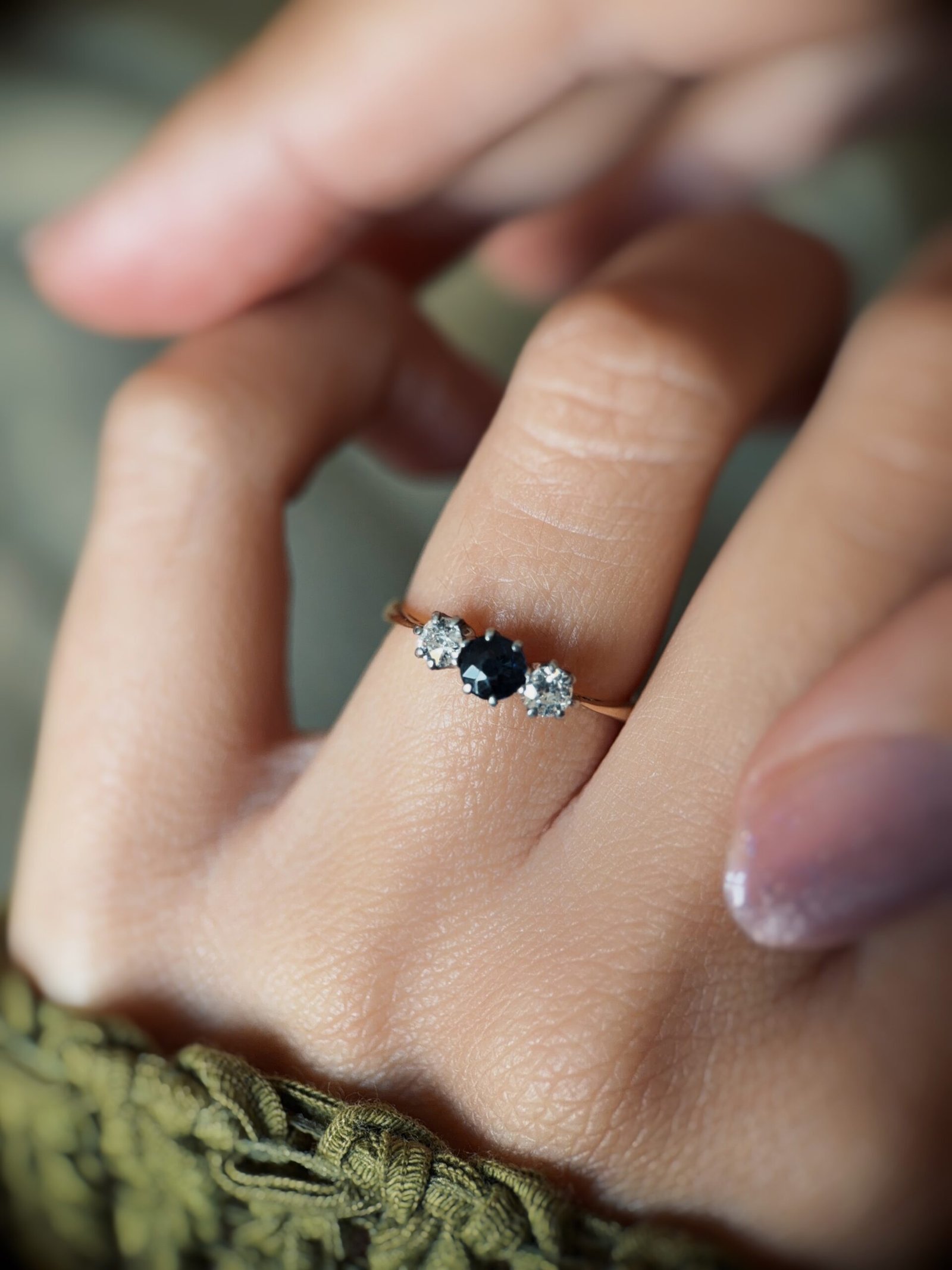 Antique 18 carat gold sapphire and old european cut diamond threestone ring worn on a hand