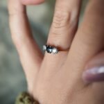 Antique 18 carat gold sapphire and old european cut diamond threestone ring worn on a hand