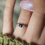 Antique 18 carat gold sapphire and old european cut diamond threestone ring worn on a hand