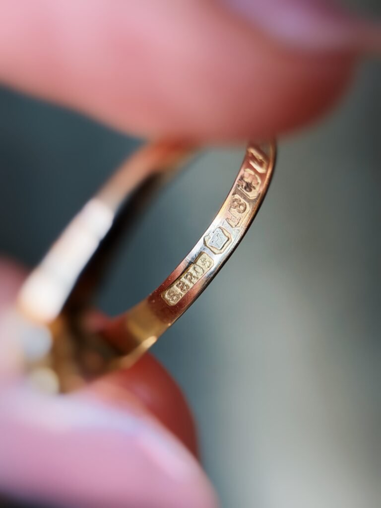 Close-up of English hallmarks inside a antique 18 carat gold ring